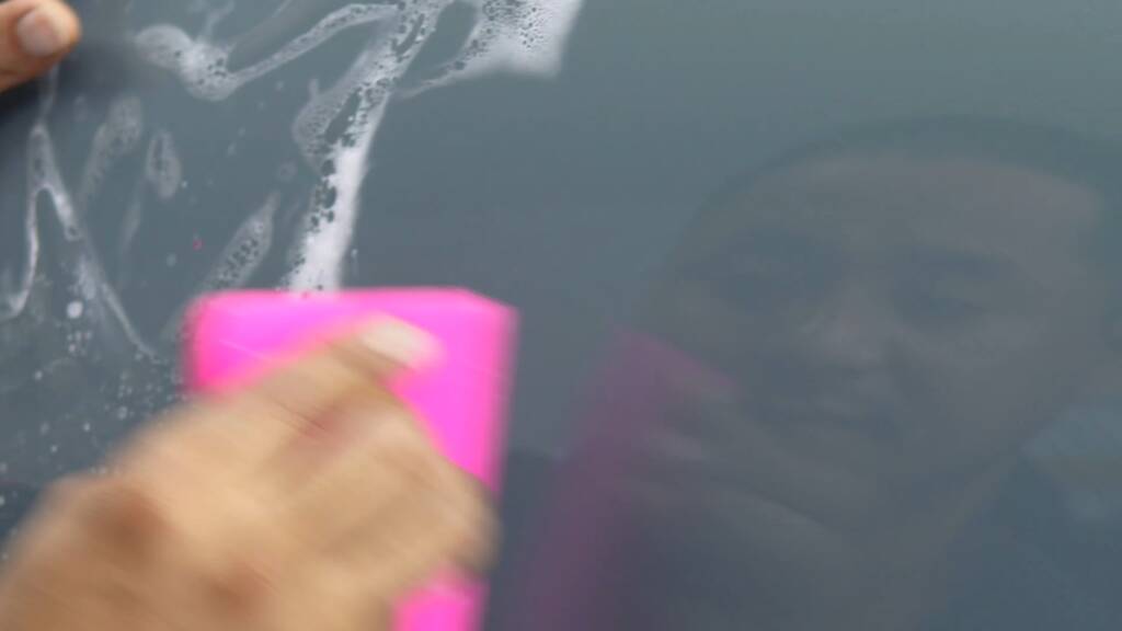 Installer squeegeeing clear PPF on a Rolls-Royce Ghost panel