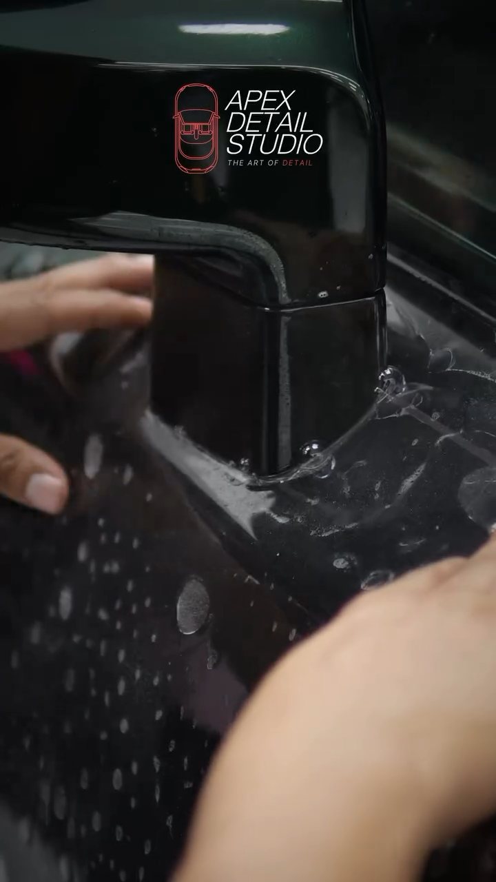 Hands positioning PPF around the Rolls-Royce Phantom door handle
