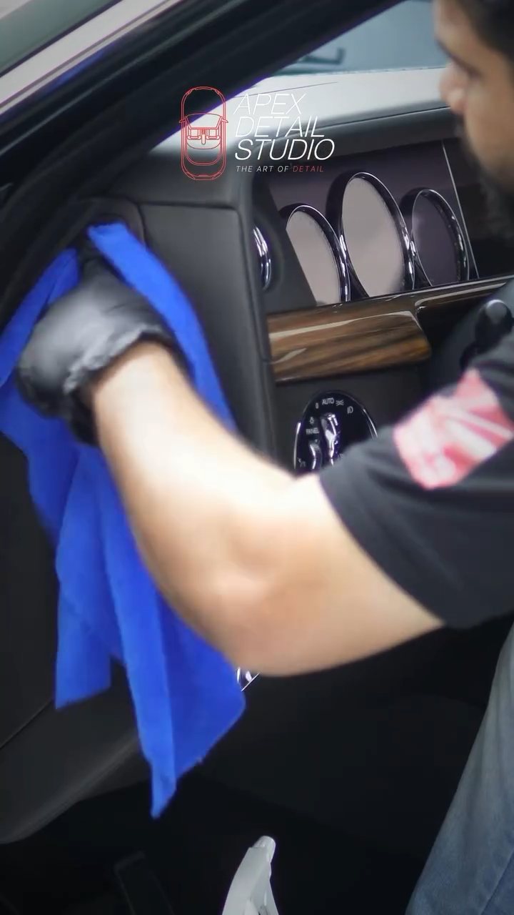 Detailer wiping the Rolls-Royce Phantom interior trim in Dubai