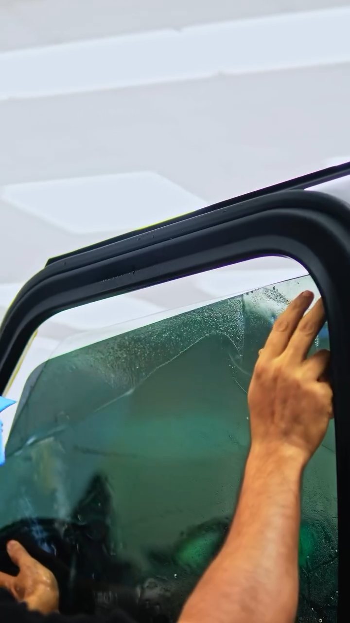 Installer squeegeeing tint on the ROX Adamas door glass in Dubai