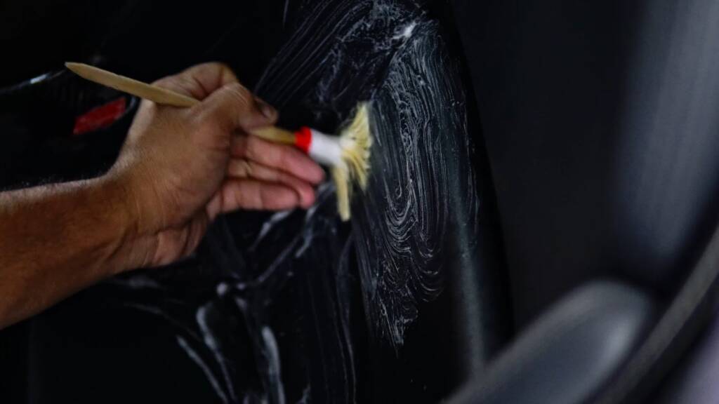 Detailer brushing the door card of a Mercedes SLR McLaren during interior detailing at Apex Detail Studio