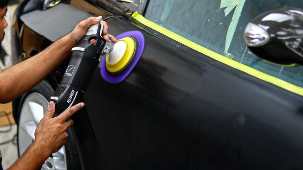 Machine polishing the black paint of a Mercedes SLR McLaren door before paint protection film in Dubai