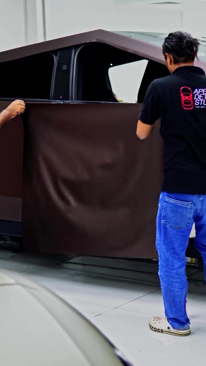 Apex installer laying brown colour change PPF over the Tesla Cybertruck rear door in Dubai