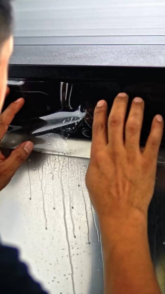 PPF tucked along a stainless steel panel edge on a Tesla Cybertruck at Apex Detail Studio
