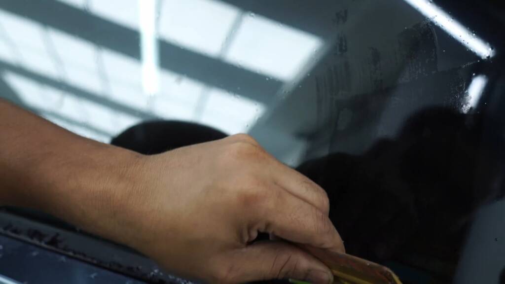 Card tool finishing a Tesla Cybertruck tint edge