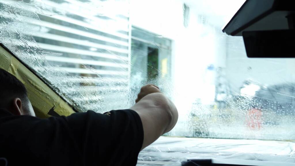 Installer applying tint inside a Tesla Cybertruck