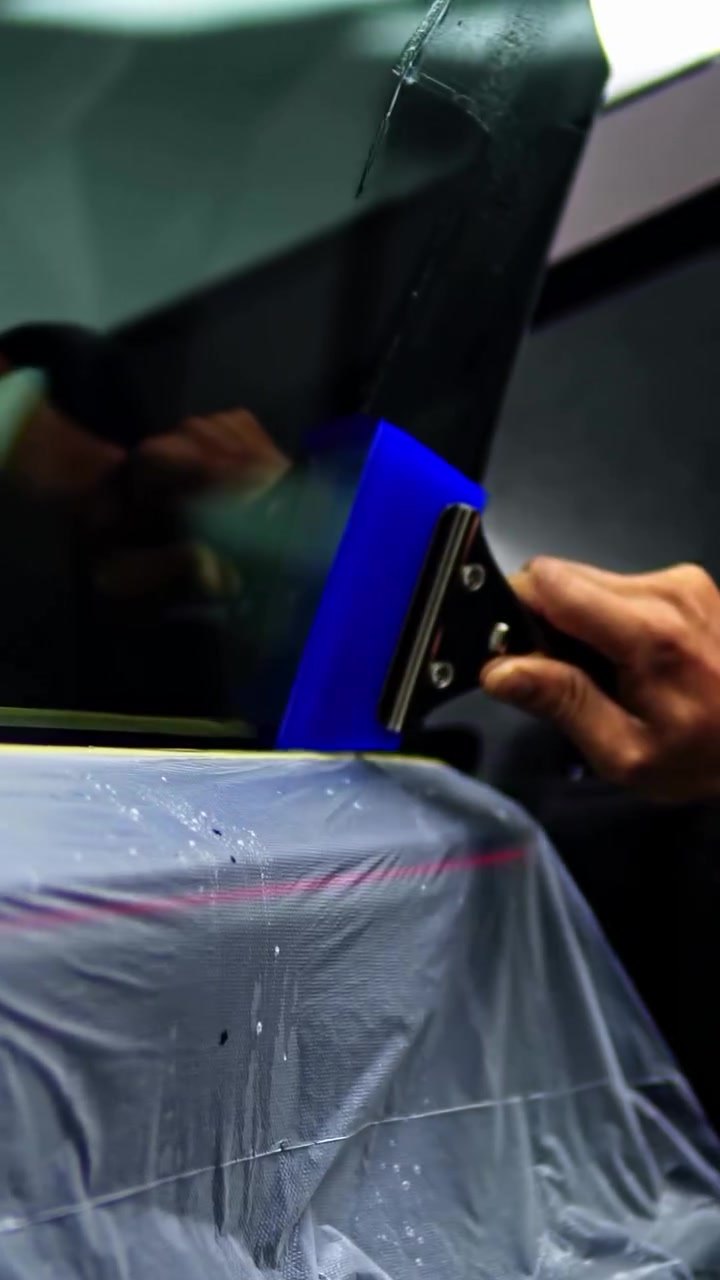 Window tint being squeegeed onto the Tesla Cybertruck glass at Apex Detail Studio Dubai