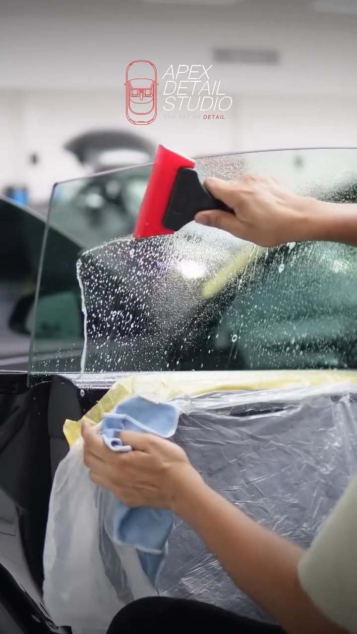 Towel catching water while tint is fitted to the Tesla Model 3 at Apex Detail Studio
