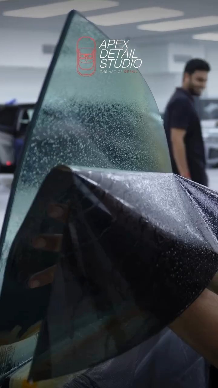 Tint film being lifted onto the Tesla Model S Plaid frameless glass in Dubai
