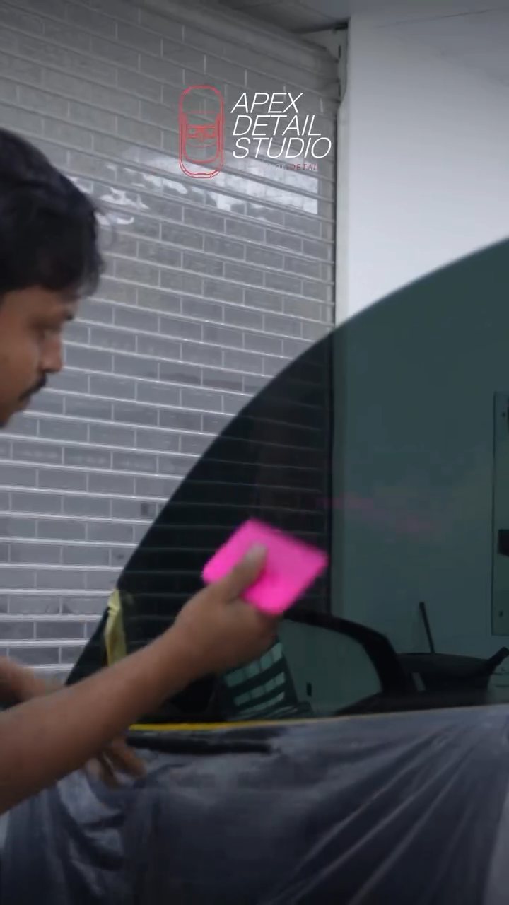 Pink squeegee finishing the Tesla Model S Plaid window tint in Dubai