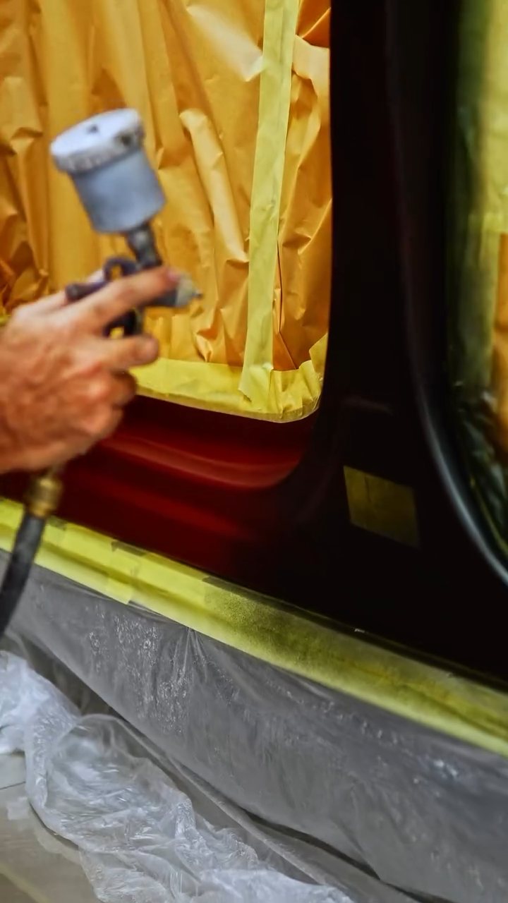 Spray gun working inside the masked Tesla Model X door shut