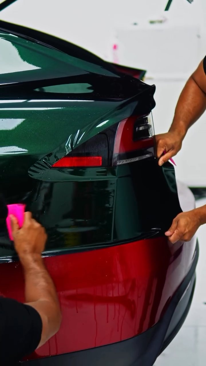 Emerald green colour PPF being squeegeed around the Tesla Model X tail light