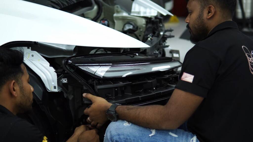 Refitting parts on a Tesla Model Y Juniper during wrap