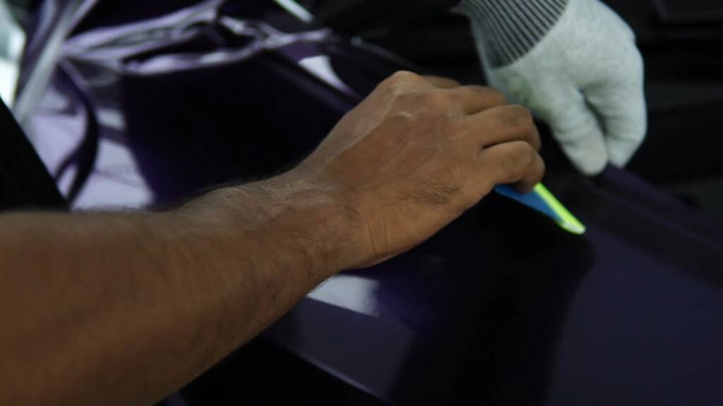 Trimming midnight purple wrap on a Tesla Model Y Juniper