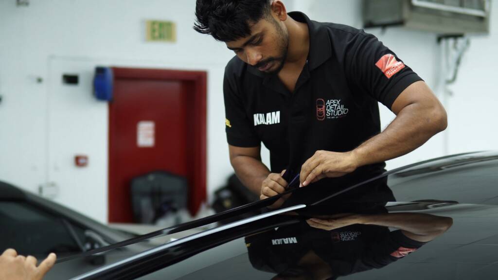 Installer working along a Tesla Model Y Juniper roof edge