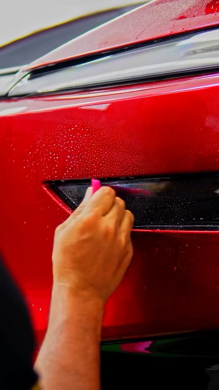Trimming PPF around the Tesla Model Y Performance headlight at Apex Detail Studio Dubai