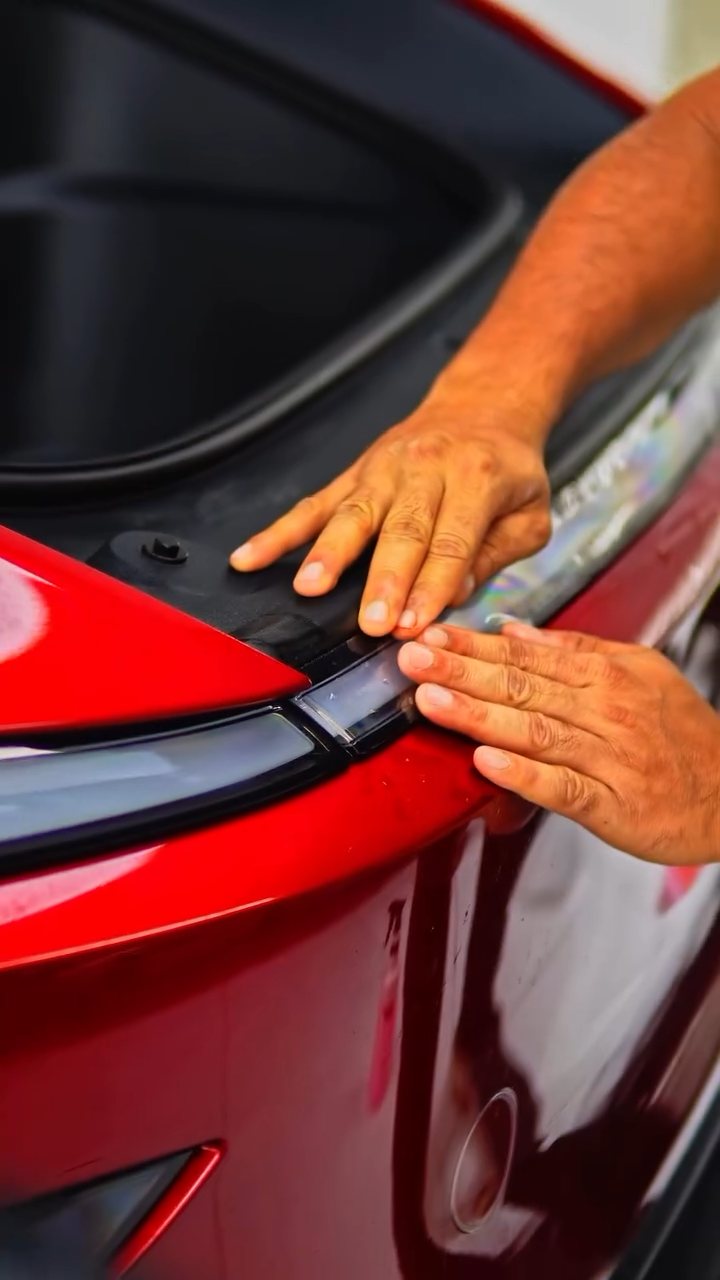 Installer tucking PPF at the Tesla Model Y tailgate edge