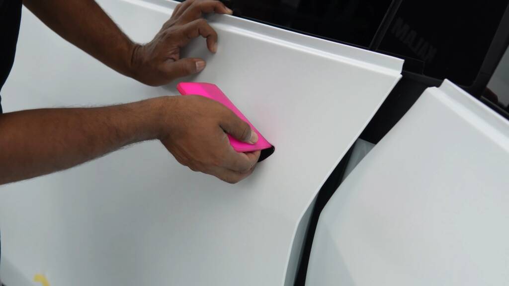 Stealth PPF being wrapped around the door edge of a Tesla Model Y Performance in Dubai