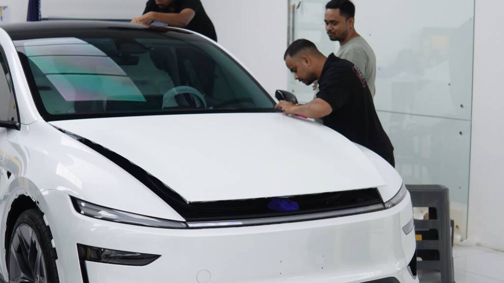 Apex installers preparing the front of a white Tesla Model Y Performance for stealth PPF