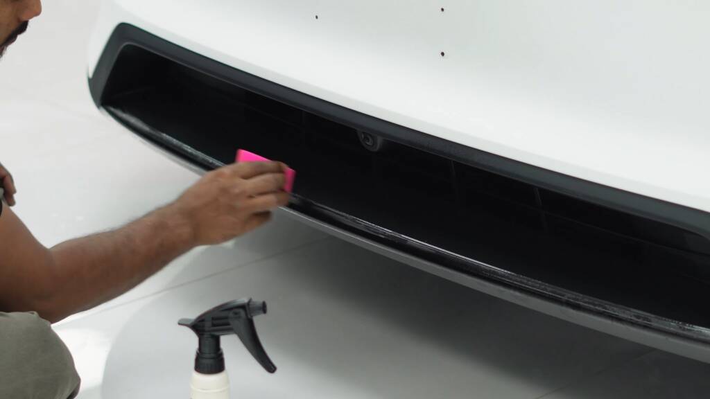 Satin PPF being squeegeed onto the rear bumper of a Tesla Model Y Performance at Apex