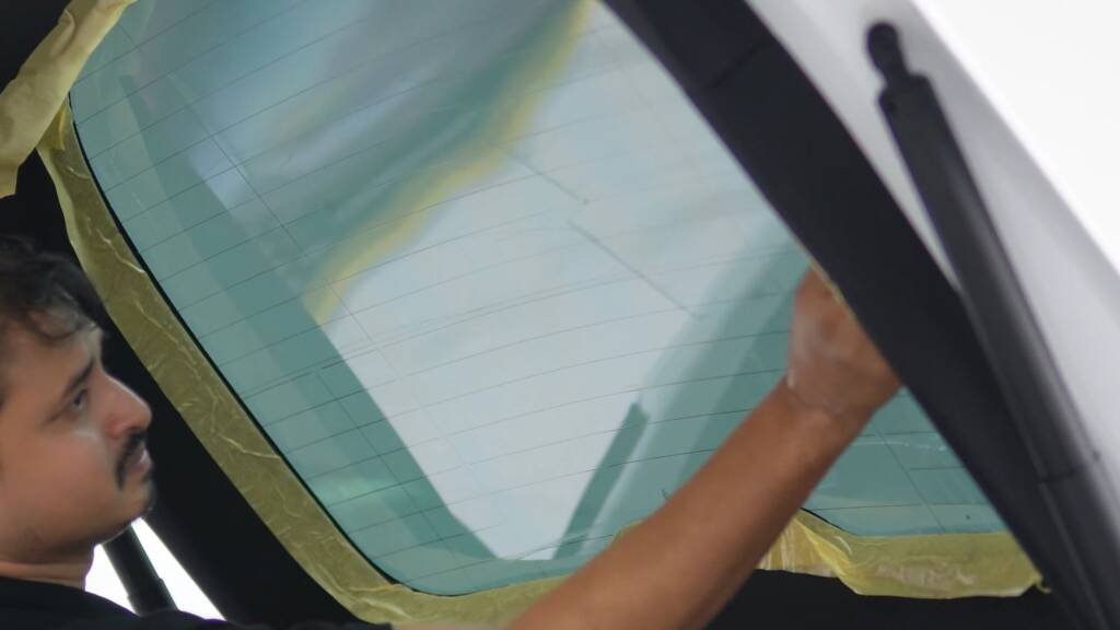 Installer fitting window film inside a Tesla Model Y Performance at Apex Dubai