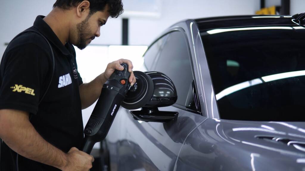 Detailer machine polishing the paint of a grey Xiaomi YU7 Max before ceramic coating