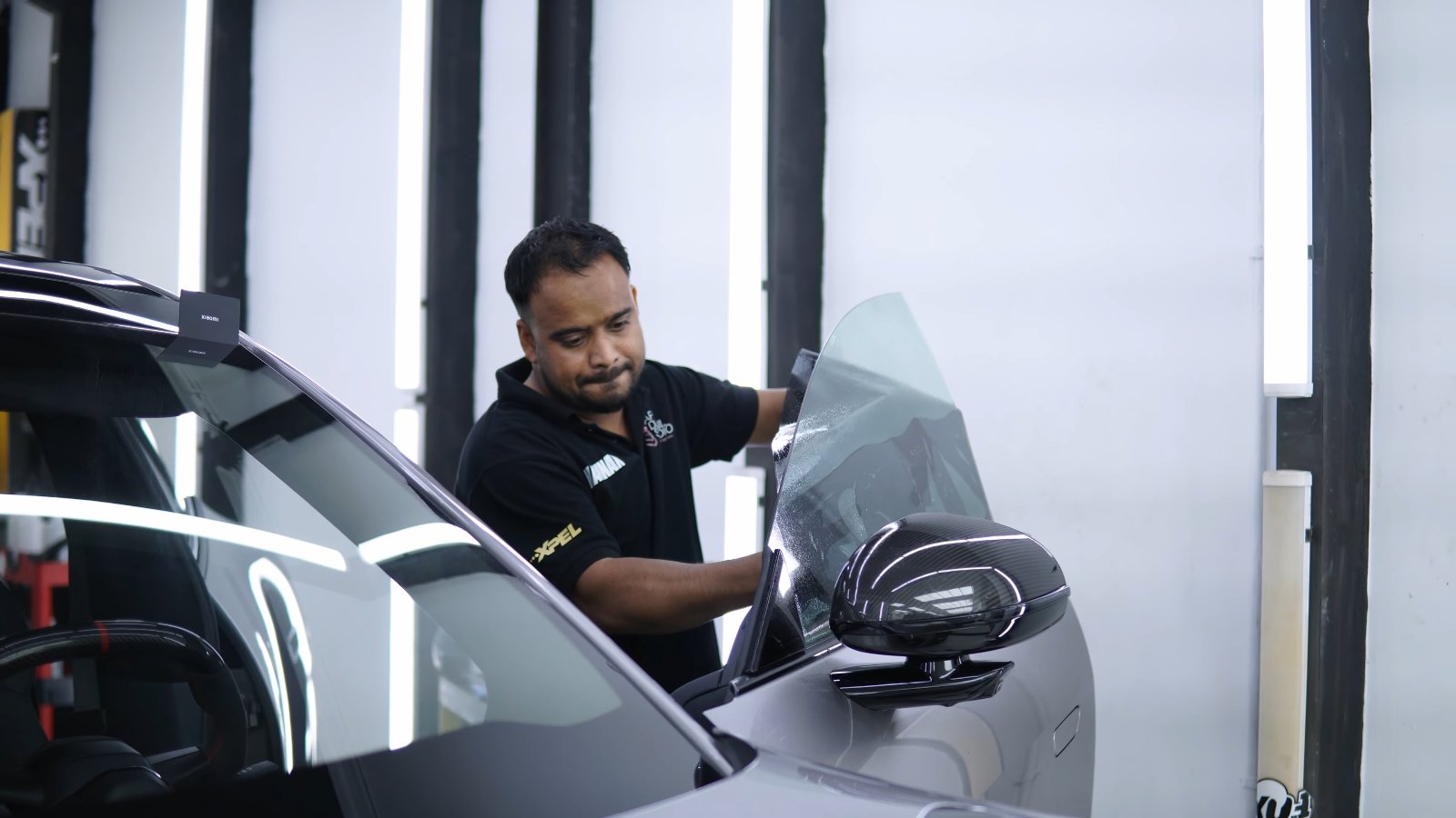 Window tint being fitted inside a Xiaomi YU7 Max side window